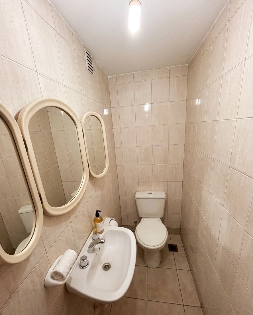 Baño con lavatorio, inodoro y espejos ovalados